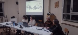 De gauche à droite : Pauline, Rachel, Denis et Françoise assit devant le diaporama. Les vélos Opair et le Tweeny Plus, destiné aux personnes en situations de handicap, sont diffusé sur l’écran blanc en arrière plan.
