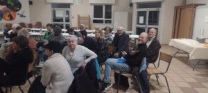 Les bénévoles assis dans l’assemblée, souriant à la photo.