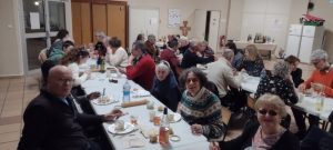 Les bénévoles, profitant de l’entrée du repas, attablés sur deux longues tables blanches.