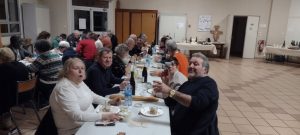 Les bénévoles, profitant de l’entrée du repas, attablés à une grande table conviviale.