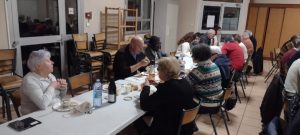 Les bénévoles, concentrés sur leur plat, attablés à une grande table conviviale.