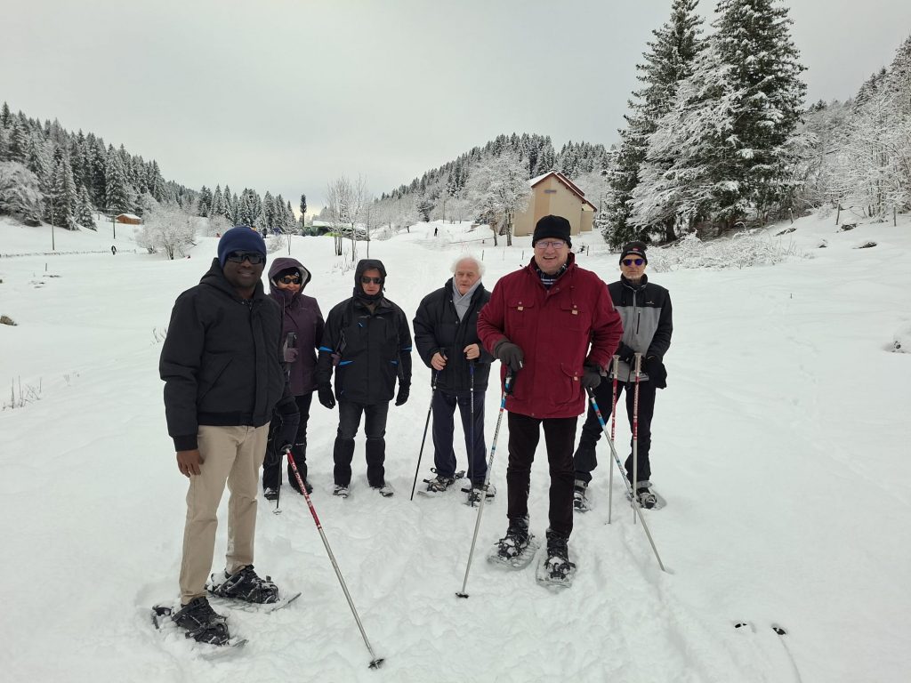 Le groupe dans la neige, des chalets et des sapins en fond, couverts de blancs.