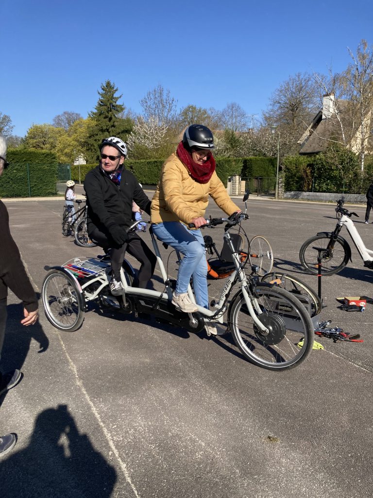 Deux cyclistes sur le tandem tricycle