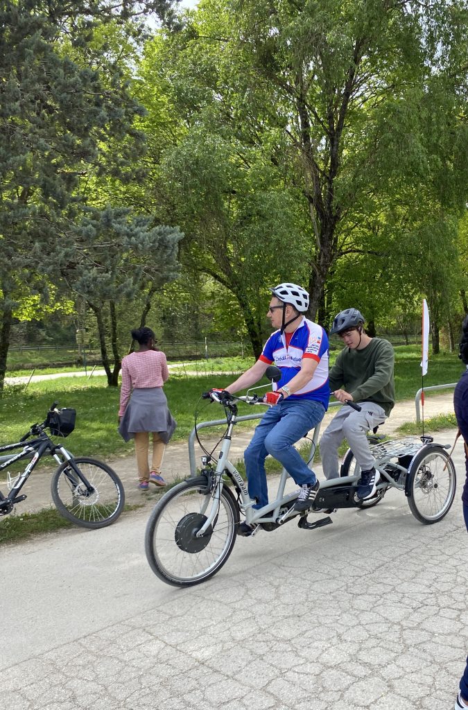 Un jeune et une bénévole sur le tandem tricycle